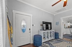 entryway with dark hardwood / wood-style flooring, ceiling fan, and crown molding