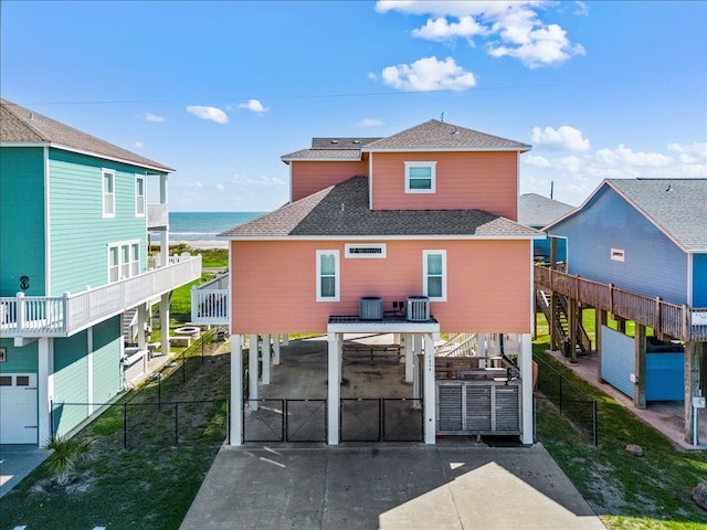 back of property with a water view and a carport