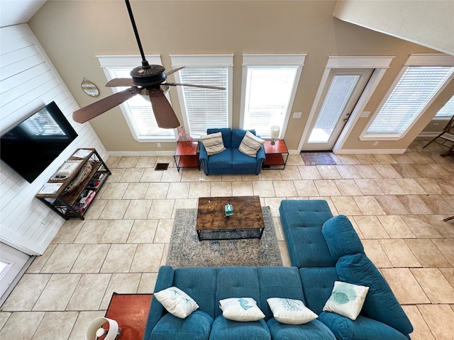 tiled living room featuring ceiling fan and high vaulted ceiling