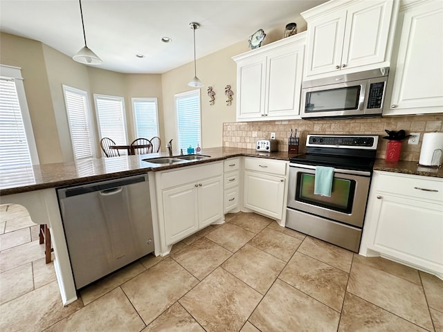 kitchen featuring sink, hanging light fixtures, a healthy amount of sunlight, stainless steel appliances, and kitchen peninsula