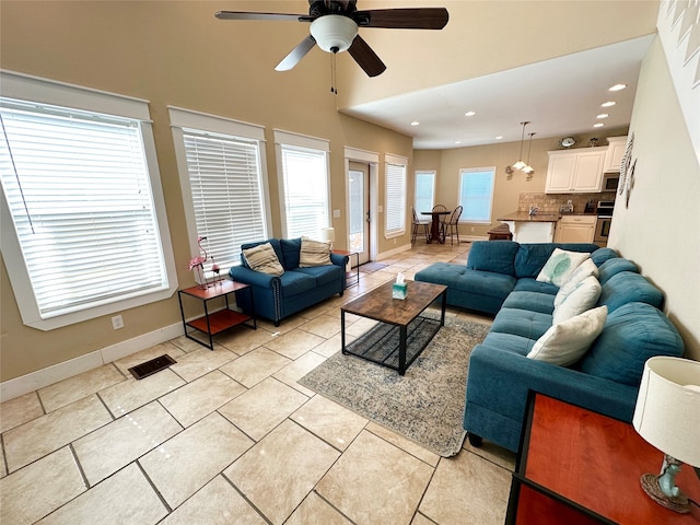 tiled living room with ceiling fan and a wealth of natural light