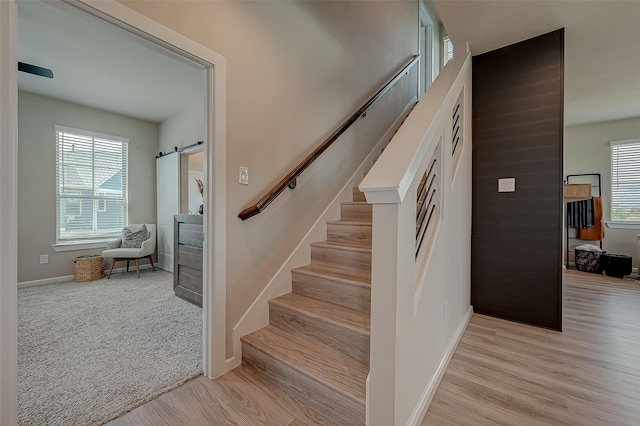 7659 Green Bulrush Way, Katy, TX 77493 - stairs featuring healthy amount of natural light, baseboards, a barn door, and wood finished floors