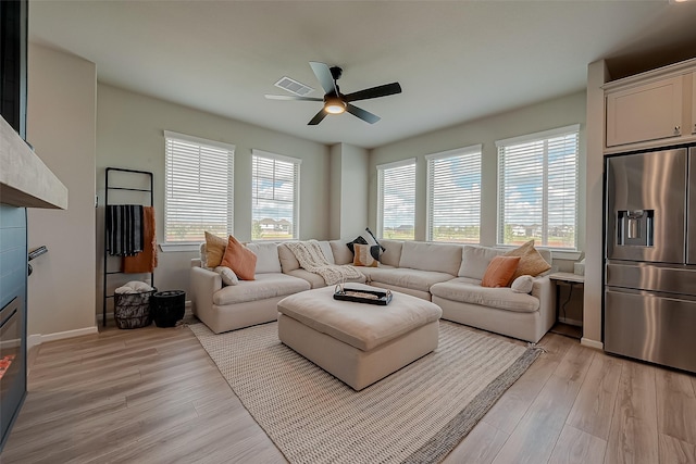 7659 Green Bulrush Way, Katy, TX 77493 - living area with a ceiling fan, light wood finished floors, a glass covered fireplace, and baseboards