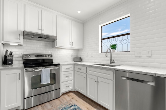 kitchen with white cabinetry, appliances with stainless steel finishes, backsplash, light stone countertops, and sink