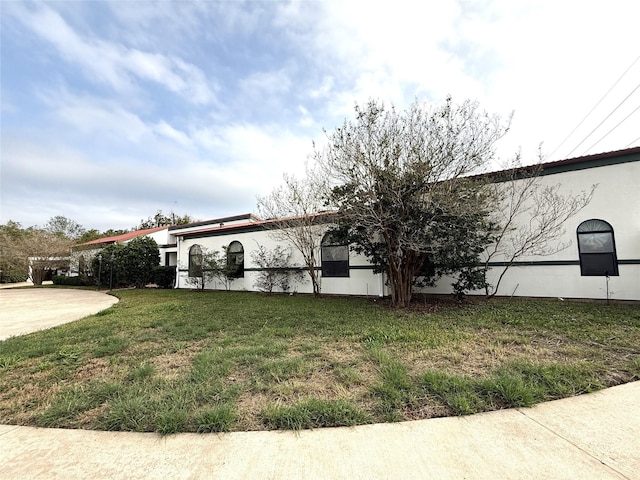 view of side of home with a yard