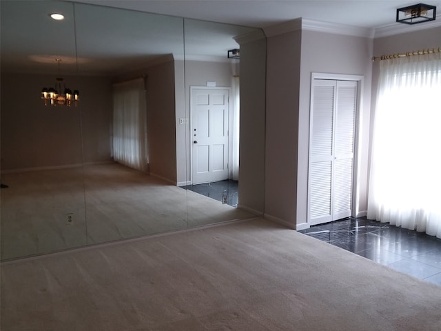 unfurnished room with dark colored carpet, a chandelier, and ornamental molding