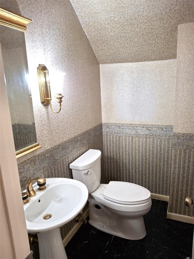 bathroom with tile patterned floors, sink, tile walls, and toilet