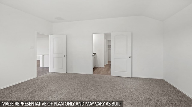 unfurnished bedroom with carpet floors and vaulted ceiling