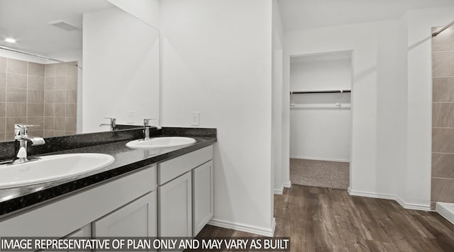 bathroom featuring hardwood / wood-style floors, vanity, and walk in shower