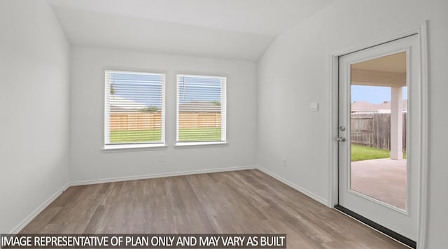 empty room with vaulted ceiling and light wood-type flooring