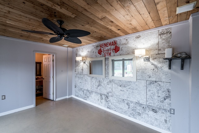 spare room with ceiling fan, wooden ceiling, and concrete floors