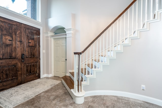 entryway featuring ornate columns and a towering ceiling