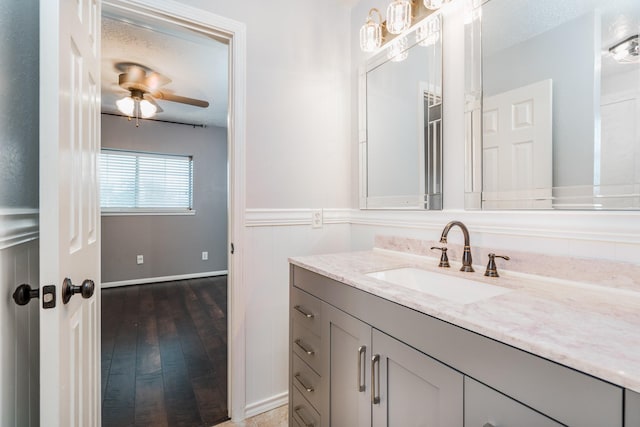 bathroom featuring vanity, ceiling fan, a textured ceiling, and wood-type flooring