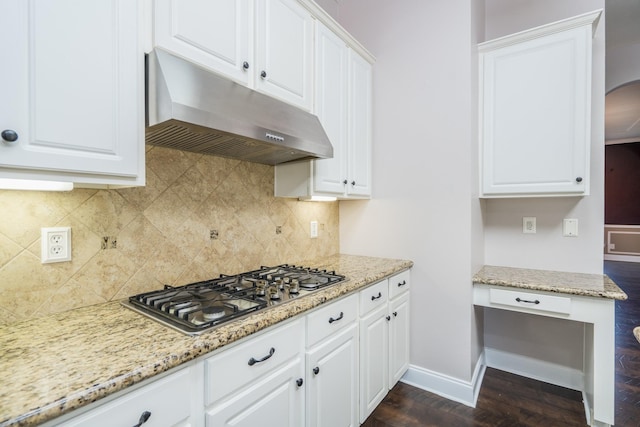 kitchen with light stone counters, white cabinetry, stainless steel gas stovetop, and dark hardwood / wood-style flooring