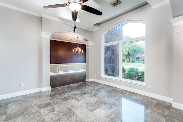 empty room with ornamental molding, a healthy amount of sunlight, ceiling fan with notable chandelier, and ornate columns