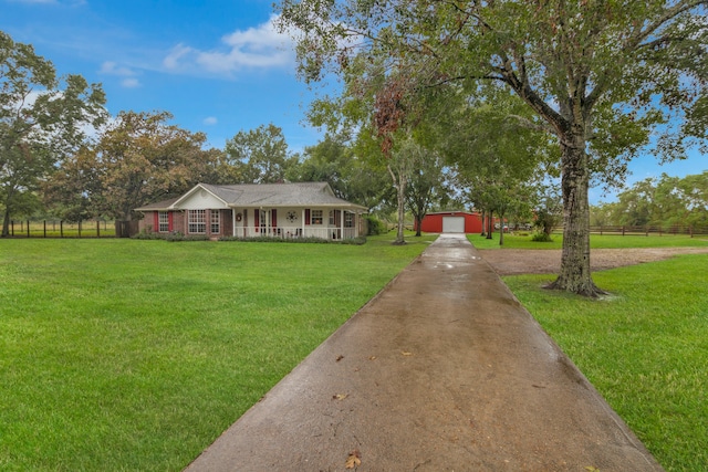 ranch-style home with an outbuilding, a front yard, covered porch, and a garage