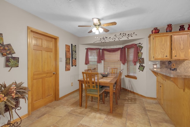 dining space featuring ceiling fan and a textured ceiling