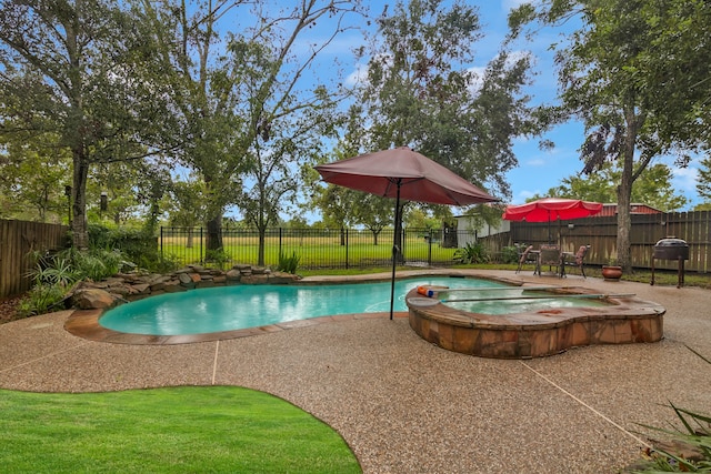 view of swimming pool featuring a patio, a lawn, and an in ground hot tub