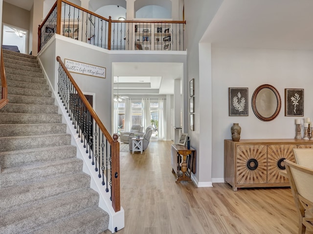 entrance foyer featuring a skylight, hardwood / wood-style flooring, and a towering ceiling