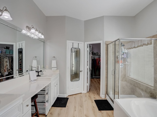 bathroom featuring shower with separate bathtub, vanity, and hardwood / wood-style floors