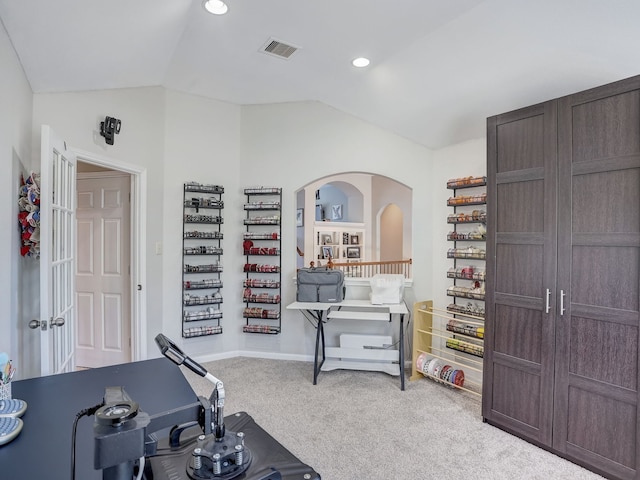 workout room featuring vaulted ceiling and light carpet