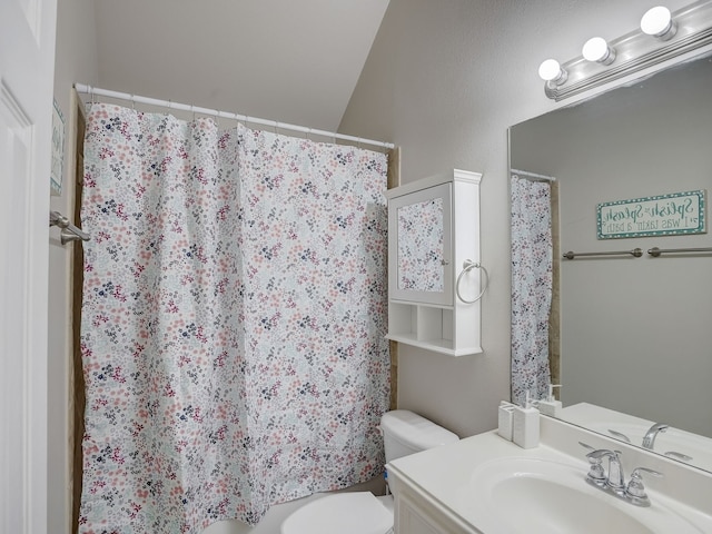 bathroom with a shower with curtain, vanity, toilet, and lofted ceiling