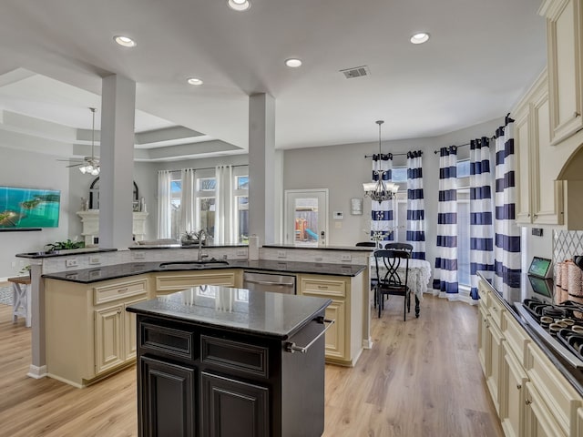 kitchen featuring stainless steel appliances, sink, kitchen peninsula, a kitchen island, and pendant lighting