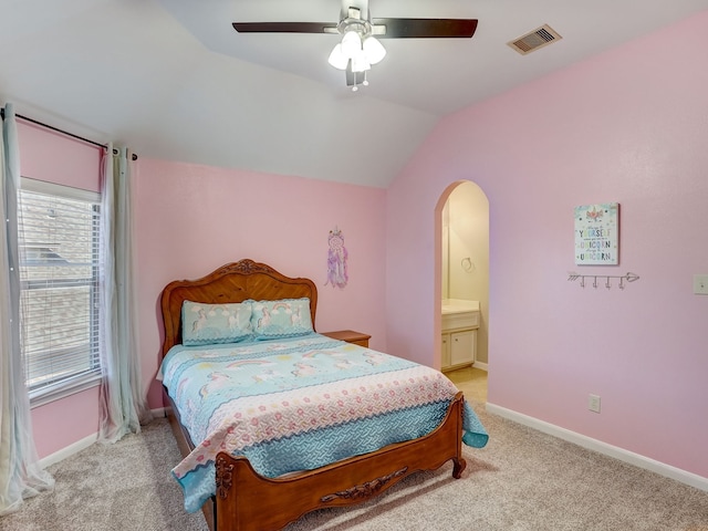 carpeted bedroom with lofted ceiling, ceiling fan, and ensuite bath