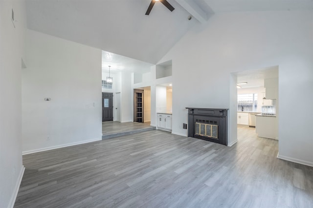 unfurnished living room with hardwood / wood-style floors, ceiling fan, beamed ceiling, and high vaulted ceiling