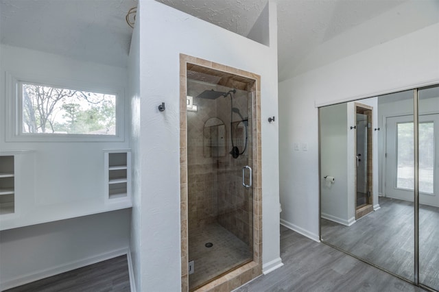 bathroom featuring walk in shower, hardwood / wood-style floors, and a textured ceiling