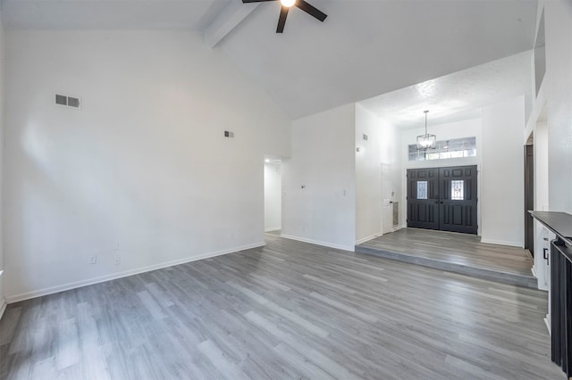 foyer with beam ceiling, light wood-type flooring, and high vaulted ceiling