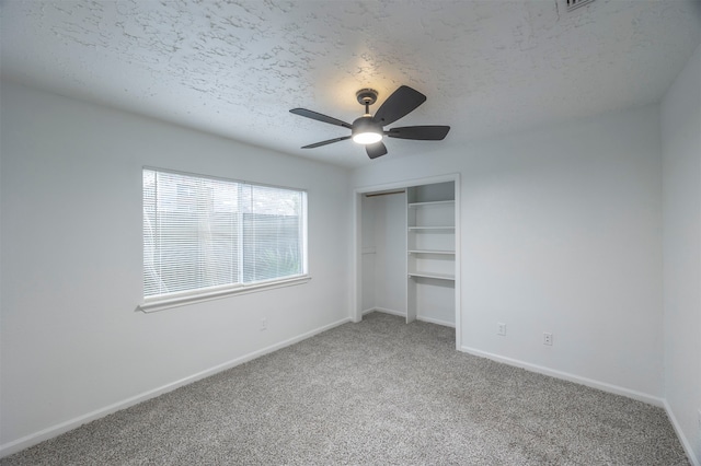 unfurnished bedroom with ceiling fan, a textured ceiling, and carpet