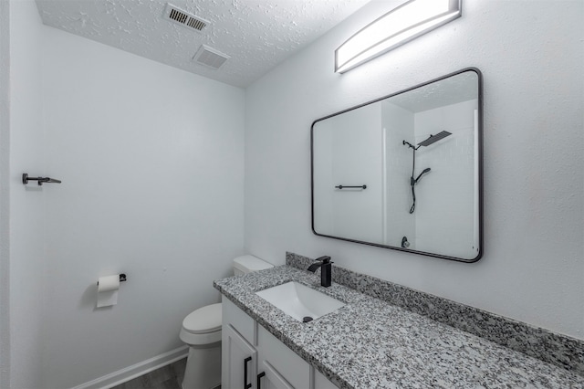 bathroom with hardwood / wood-style floors, vanity, a textured ceiling, and toilet