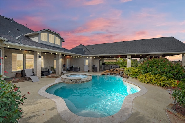 pool at dusk featuring an in ground hot tub and a patio area