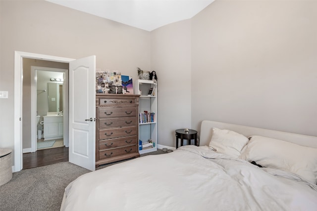 bedroom with hardwood / wood-style floors and ensuite bath