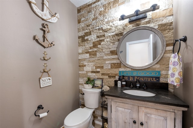 bathroom with vanity, toilet, and backsplash