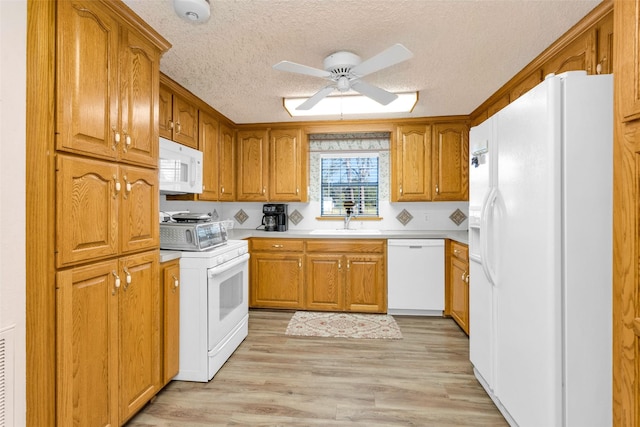 kitchen with white appliances, a textured ceiling, sink, light wood-type flooring, and ceiling fan