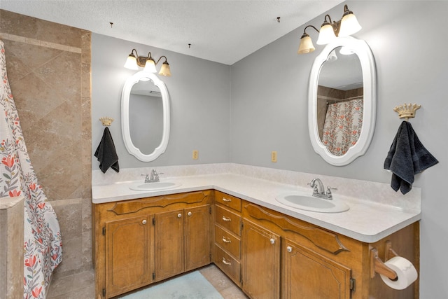 bathroom with a textured ceiling, tile patterned floors, and vanity