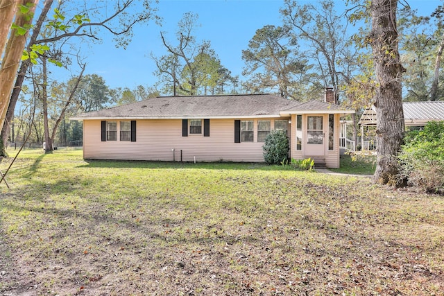 back of property featuring a lawn and a chimney