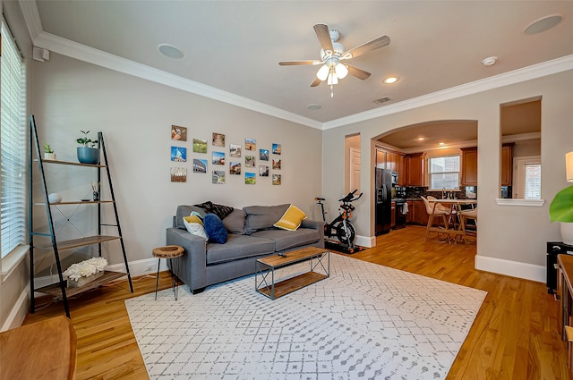 living room featuring ornamental molding, ceiling fan, sink, and light hardwood / wood-style floors