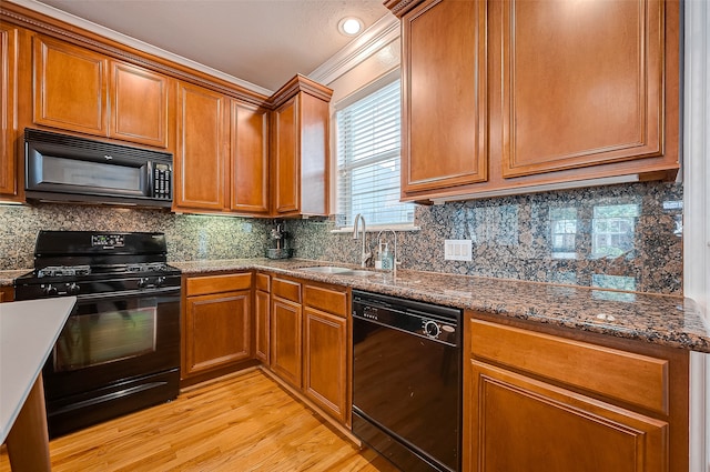 kitchen featuring black appliances, decorative backsplash, sink, dark stone countertops, and light hardwood / wood-style flooring