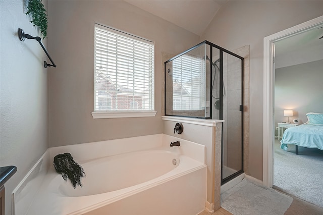 bathroom with tile patterned floors, separate shower and tub, and lofted ceiling