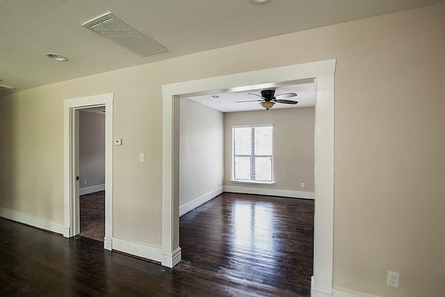 spare room featuring dark hardwood / wood-style flooring and ceiling fan