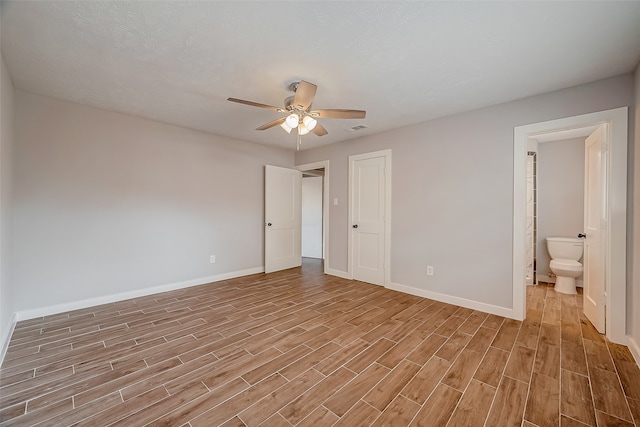 unfurnished bedroom with connected bathroom, light wood-type flooring, and ceiling fan