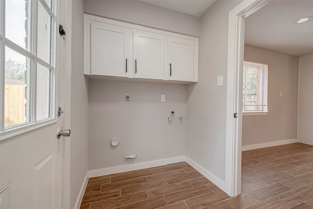 laundry area with cabinets, hardwood / wood-style flooring, hookup for an electric dryer, and gas dryer hookup