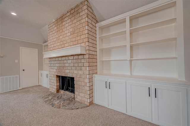 unfurnished living room featuring a fireplace, light colored carpet, built in shelves, and vaulted ceiling