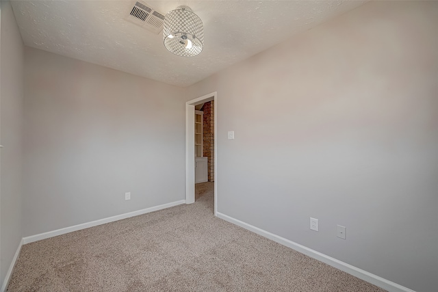 unfurnished room featuring a textured ceiling and carpet