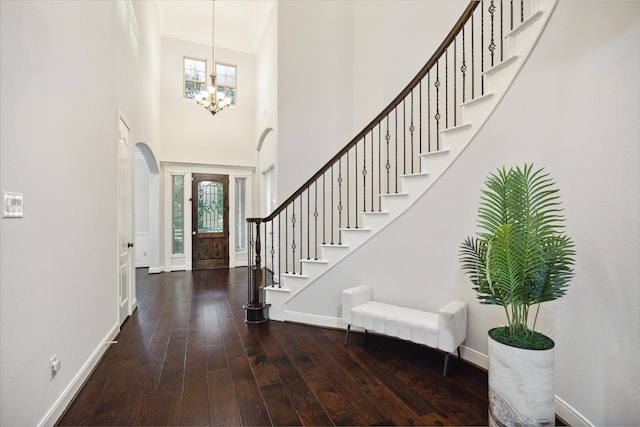 entrance foyer featuring a high ceiling, a chandelier, dark hardwood / wood-style flooring, and ornamental molding