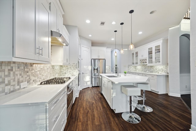 kitchen featuring dark wood-type flooring, white cabinetry, decorative backsplash, and stainless steel appliances