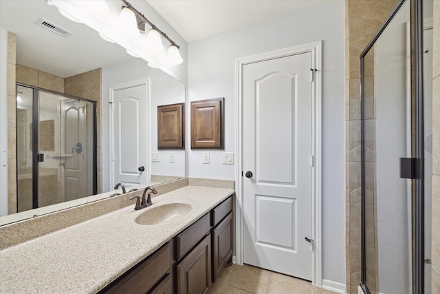 bathroom with walk in shower, vanity, and tile patterned floors